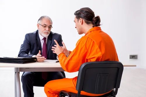 Abogado en derecho penal durante una consulta con una persona detenida