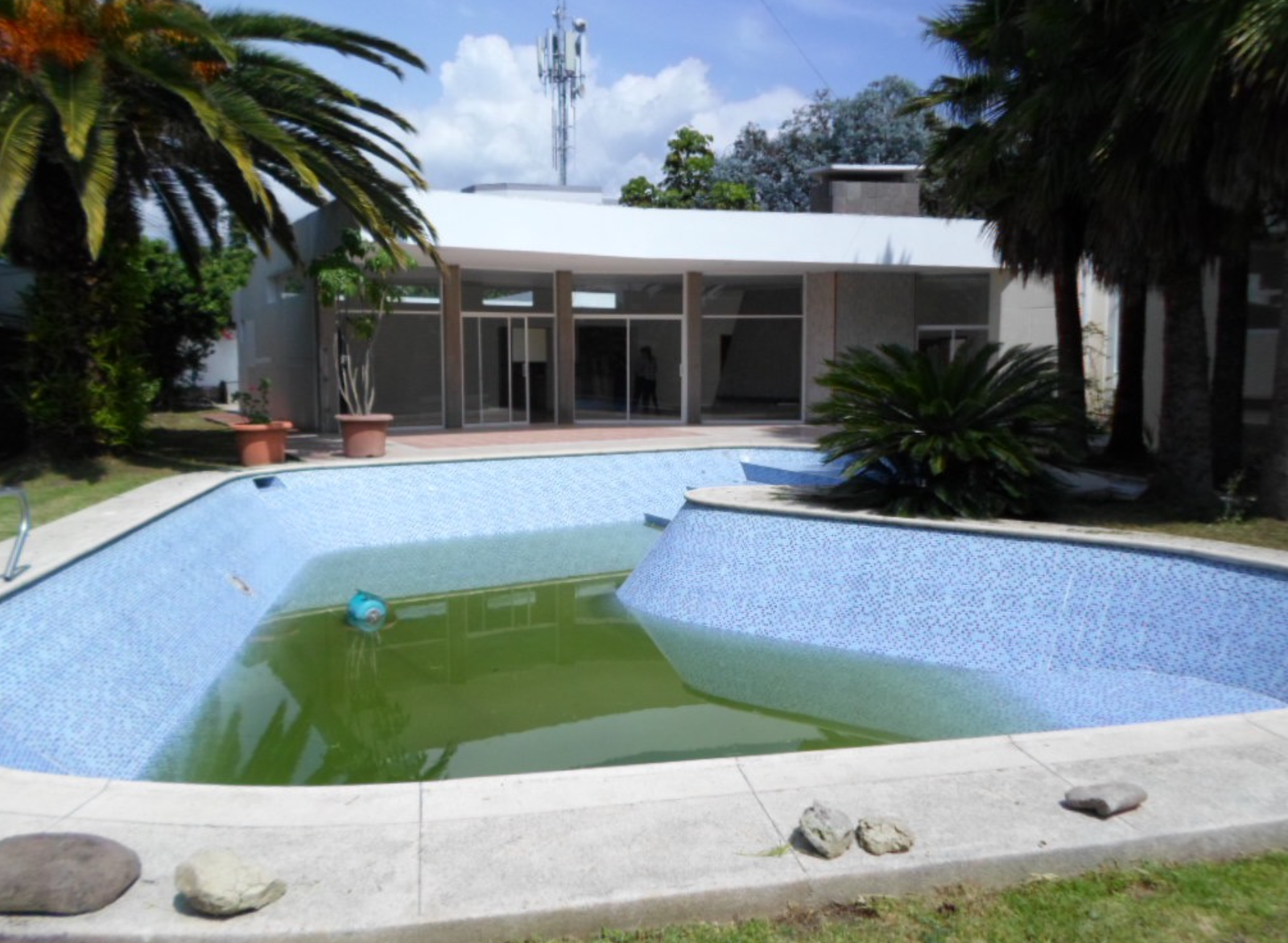 EC-RJ-158109 — Piscina de la propiedad Piscina parcialmente llena y casa al fondo