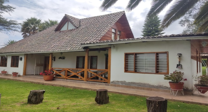 EC-RJ-157500 — Portada de casa en Tumbaco Fachada de casa con cubierta inclinada y jardín en Tumbaco